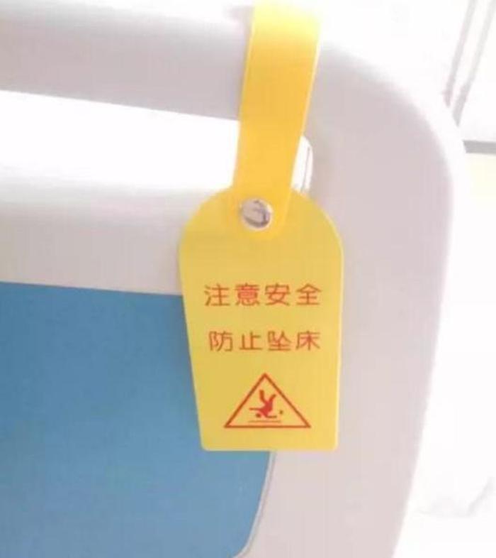老人卧床时上好床栏,床尾悬挂"防跌倒,防坠床"警示标识,走廊墙壁粘贴
